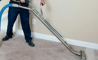 Professional operating a liquid removal machine on a carpeted floor in Louisville, KY